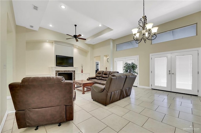 tiled living room featuring ceiling fan with notable chandelier, a high ceiling, and french doors