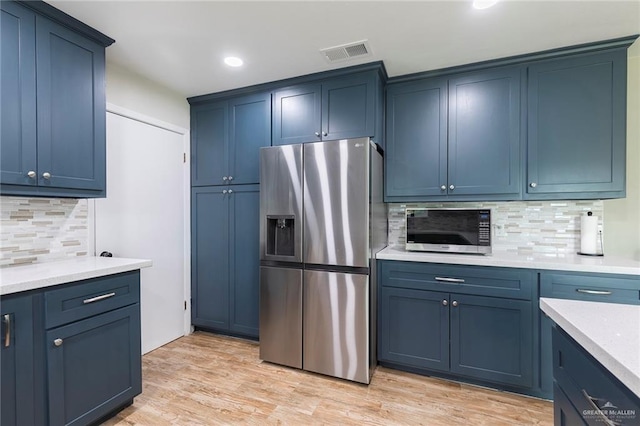 1409 Pine Ct, Harlingen, TX 78550 - kitchen featuring stainless steel appliances, backsplash, blue cabinetry, recessed lighting, and light wood finished floors