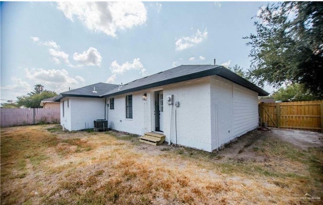 rear view of property with central AC