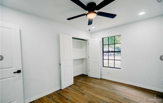 unfurnished bedroom with ceiling fan, dark wood-type flooring, and a closet