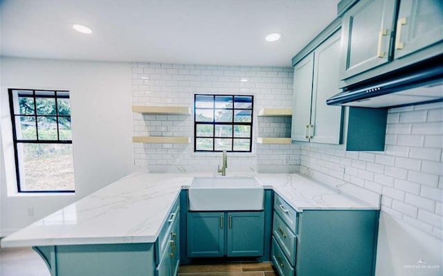 kitchen with kitchen peninsula, plenty of natural light, and sink