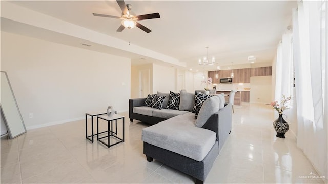 living room featuring light tile patterned flooring and ceiling fan with notable chandelier