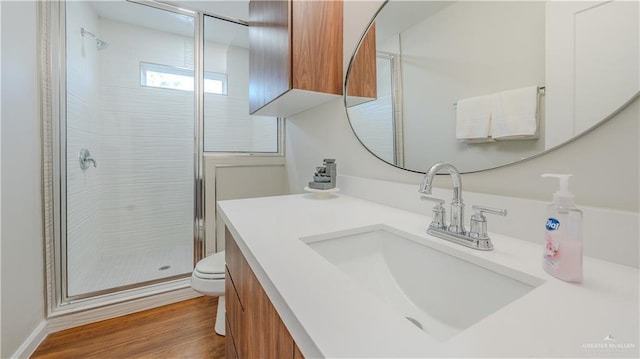 bathroom featuring hardwood / wood-style floors, vanity, toilet, and walk in shower