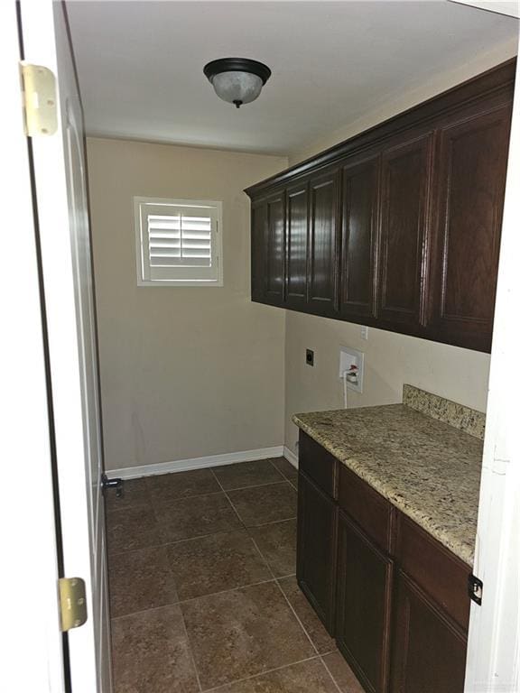 laundry room featuring washer hookup, dark tile patterned floors, hookup for an electric dryer, cabinet space, and baseboards