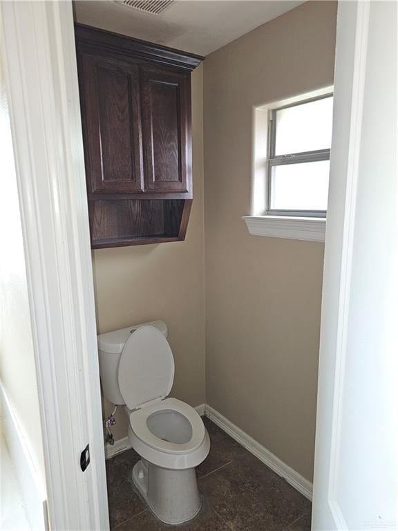 bathroom featuring toilet, baseboards, and visible vents