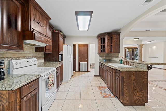 kitchen with white appliances, visible vents, glass insert cabinets, and a sink