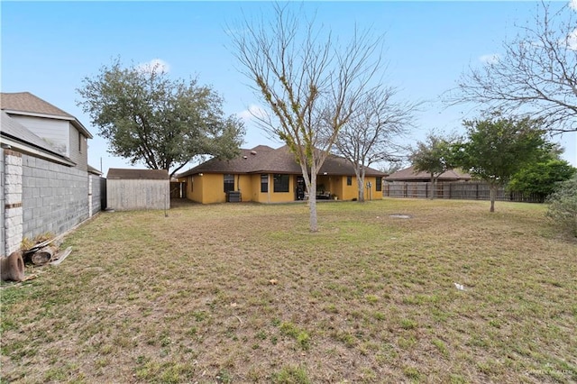 view of yard featuring a storage unit, an outdoor structure, and a fenced backyard