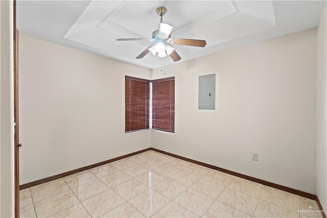 unfurnished room with light tile patterned flooring, a ceiling fan, baseboards, electric panel, and a tray ceiling