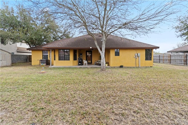 back of house with a patio area, a fenced backyard, a yard, and stucco siding