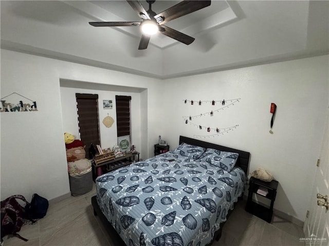 bedroom featuring a raised ceiling and a ceiling fan