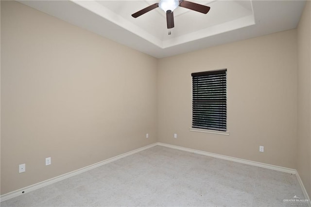 empty room with a raised ceiling and ceiling fan