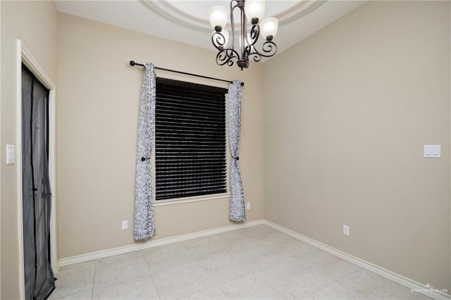 tiled empty room with a chandelier