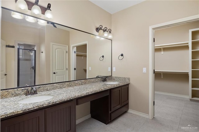 bathroom with tile patterned flooring, vanity, and a shower with shower door