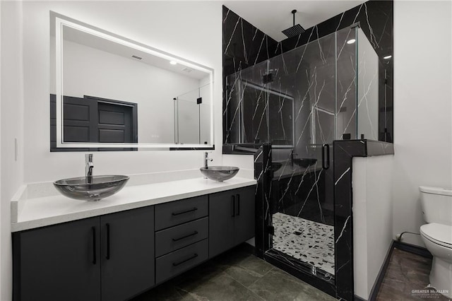 509 Demi St, Edinburg, TX 78542 - full bathroom featuring toilet, double vanity, a sink, and a marble finish shower