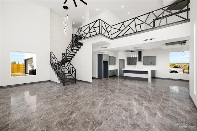 509 Demi St, Edinburg, TX 78542 - unfurnished living room with stairway, a high ceiling, baseboards, and marble finish floor