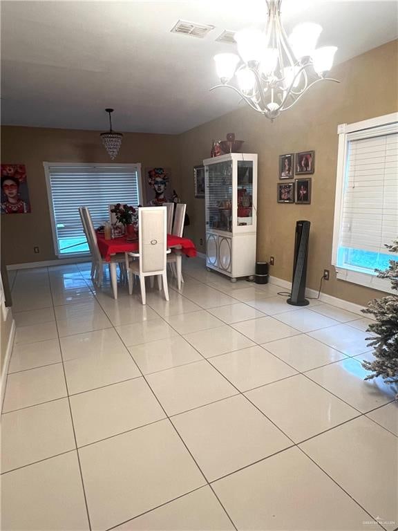 dining space with light tile patterned floors and a notable chandelier