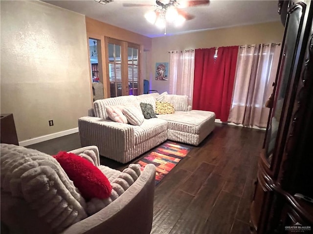 living room with dark hardwood / wood-style flooring and ceiling fan