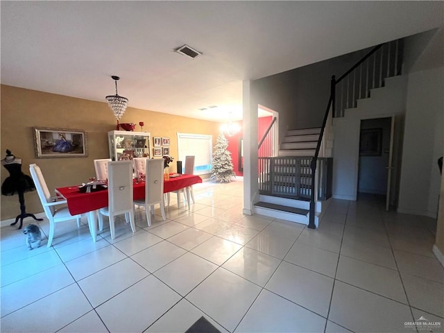 dining space with light tile patterned flooring and a notable chandelier