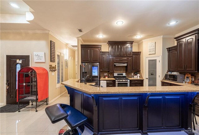 1033 Esteban Ave, Pharr, TX 78577 - kitchen featuring appliances with stainless steel finishes, baseboards, tasteful backsplash, a breakfast bar, and ornamental molding