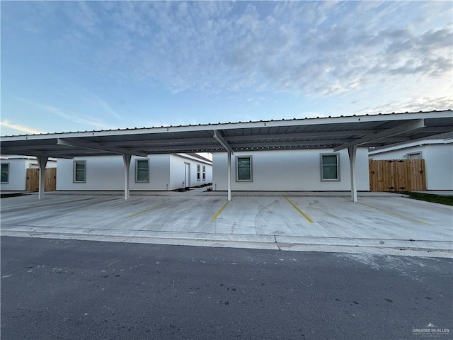 back of house featuring covered parking and fence