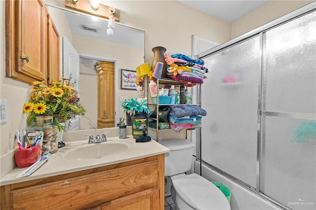 full bathroom featuring vanity, toilet, and combined bath / shower with glass door