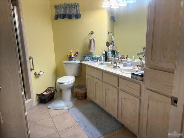 bathroom with toilet, double vanity, a stall shower, tile patterned floors, and a sink