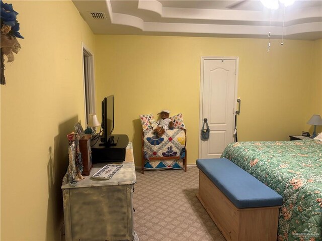 bedroom featuring a raised ceiling, baseboards, visible vents, and carpet floors