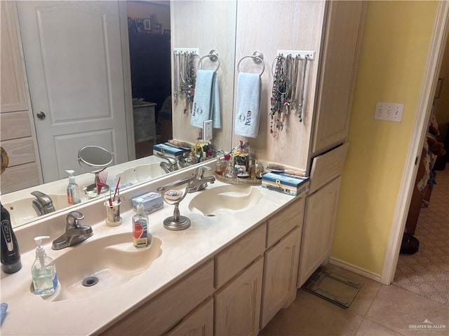 bathroom featuring tile patterned floors, double vanity, baseboards, and a sink