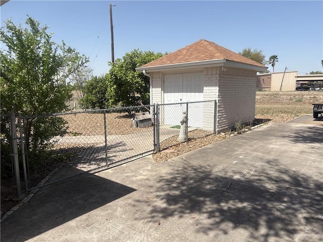 exterior space with an outdoor structure, a gate, and fence