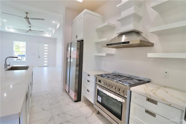 kitchen with white cabinetry, sink, exhaust hood, stainless steel appliances, and light stone countertops