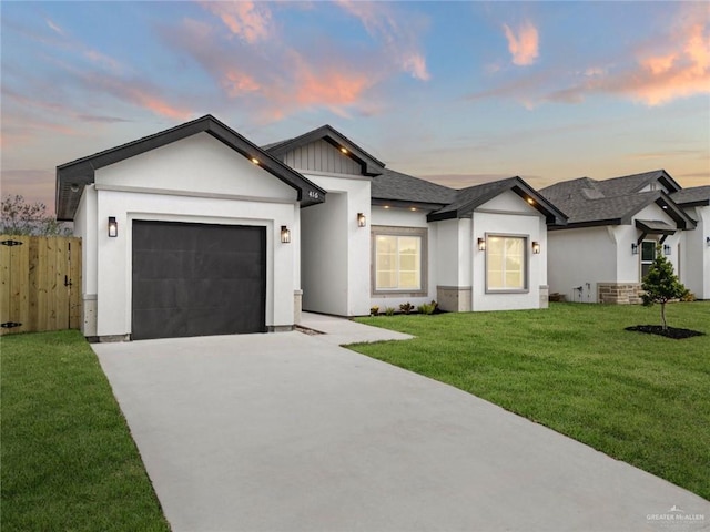 view of front of home with a yard and a garage