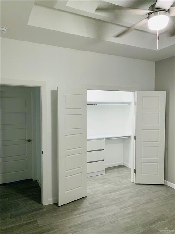 interior space featuring hardwood / wood-style floors, ceiling fan, and a closet