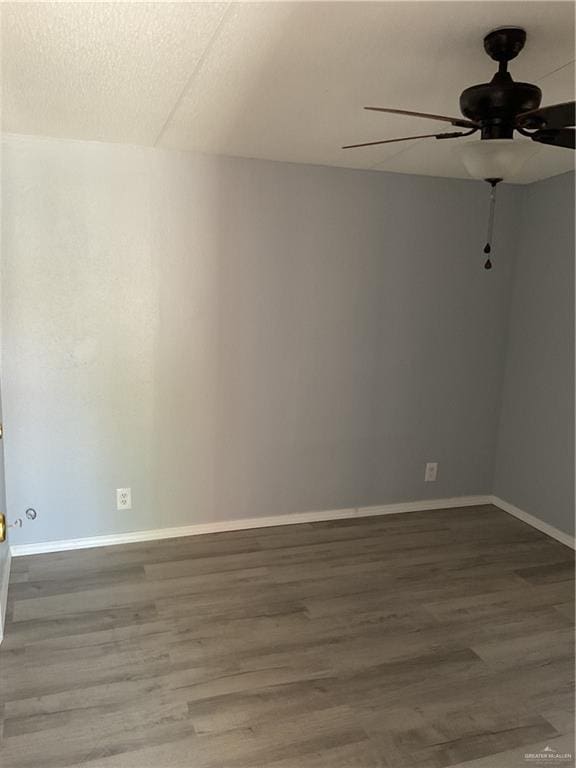 spare room featuring wood finished floors, a ceiling fan, baseboards, and a textured ceiling