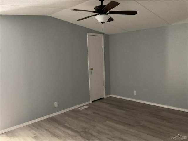 spare room with baseboards, lofted ceiling, ceiling fan, and wood finished floors