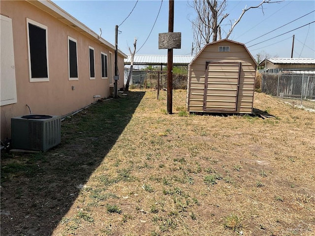 view of yard featuring central air condition unit, an outbuilding, a fenced backyard, and a storage shed