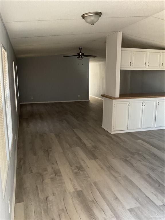 unfurnished living room featuring dark wood finished floors and a ceiling fan