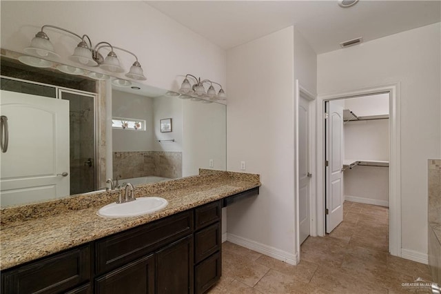 bathroom with a garden tub, visible vents, baseboards, a spacious closet, and a stall shower