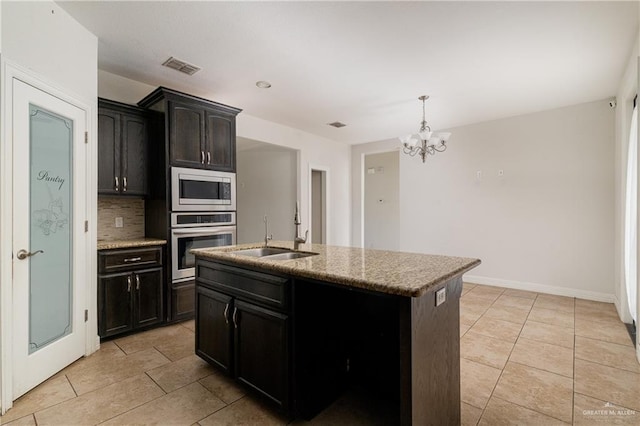 kitchen featuring stainless steel appliances, visible vents, decorative backsplash, light tile patterned flooring, and a sink