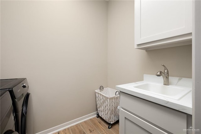 laundry area featuring sink, washer and clothes dryer, and cabinets