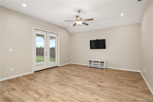 unfurnished living room featuring french doors, ceiling fan, vaulted ceiling, and light hardwood / wood-style floors