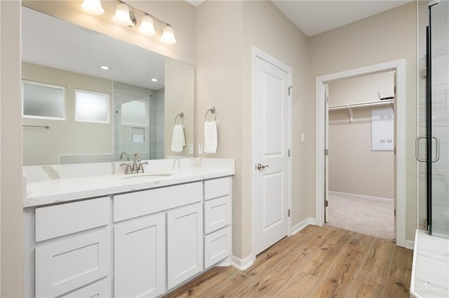 bathroom with vanity, hardwood / wood-style floors, and a shower with door