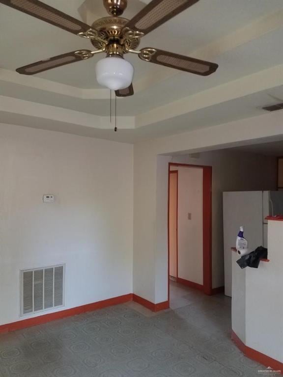 unfurnished room featuring a tray ceiling and ceiling fan