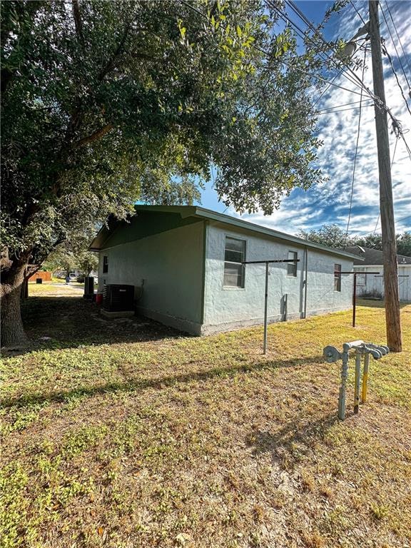 view of property exterior featuring a yard and central AC unit