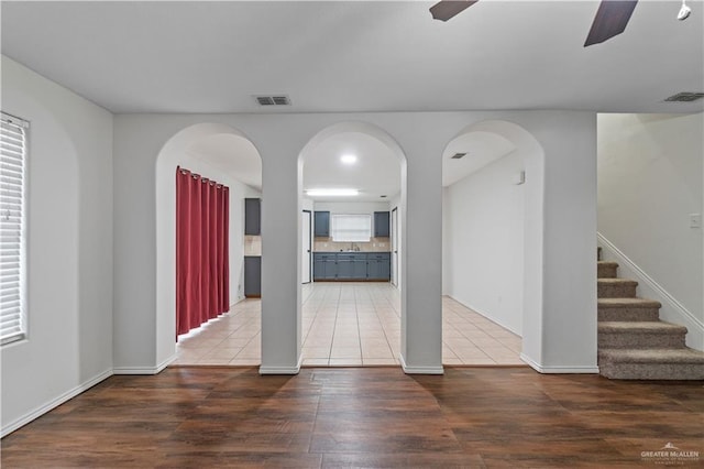 3017 Paradise Ave, Harlingen, TX 78552 - unfurnished living room with light wood finished floors, stairs, ceiling fan, and arched walkways