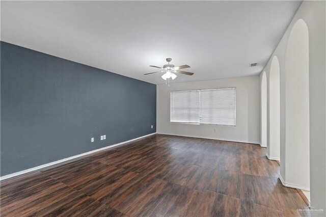 3017 Paradise Ave, Harlingen, TX 78552 - empty room with ceiling fan, dark wood finished floors, and arched walkways