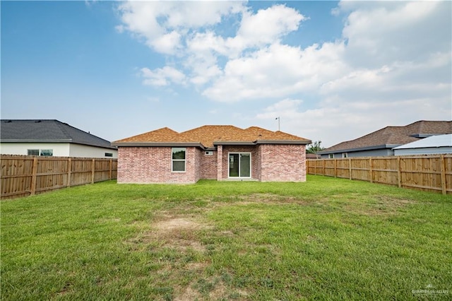 rear view of house featuring a yard