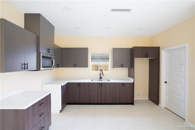 kitchen with dark brown cabinetry and sink