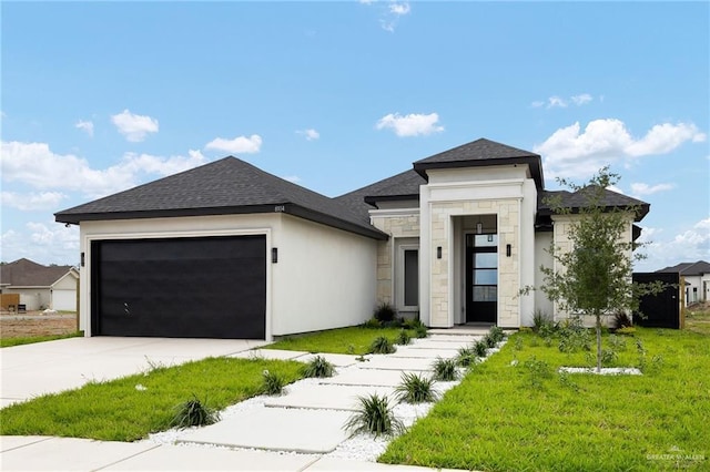 8104 N 51st St N, Mcallen, TX 78504 - prairie-style home featuring roof with shingles, a front lawn, concrete driveway, an attached garage, and stone siding