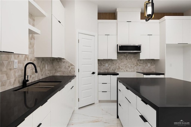 8104 N 51st St N, Mcallen, TX 78504 - kitchen with decorative backsplash, marble finish floor, dark countertops, stainless steel microwave, and a sink