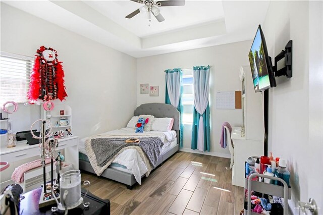 8718 Pink Flamingo St, Harlingen, TX 78552 - bedroom with multiple windows, a tray ceiling, ceiling fan, and light wood-style floors